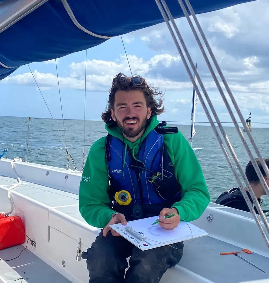 Léo souriant à bord d'un bateau, gilet de sauvetage porté